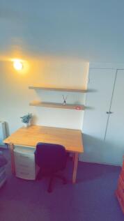 A well-lit, tidy study corner featuring a woode...