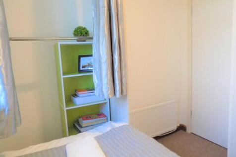 Bright, tidy bedroom with neutral decor and tas...