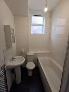 Bright bathroom with a full-sized bath and wind...