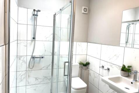 Modern bathroom featuring a glass-enclosed show...