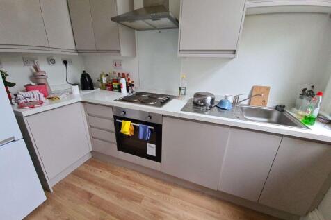 Modern fitted kitchen with integrated oven, ele...