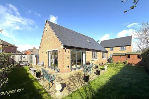 Sun-drenched garden with patio and lush lawn...