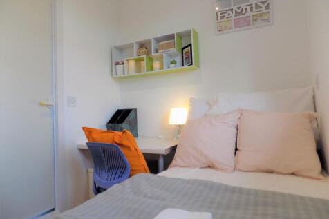 Bright, neatly styled bedroom with a compact st...
