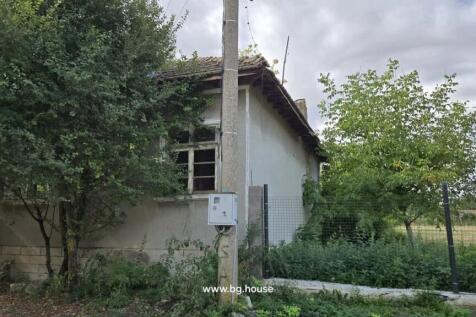Side elevation of the house featuring a tiled roof, window, and an electrical pole in the foreground