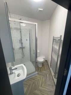 Modern bathroom featuring a glass-enclosed show...