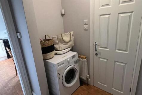Neat entry hallway with a compact utility area ...