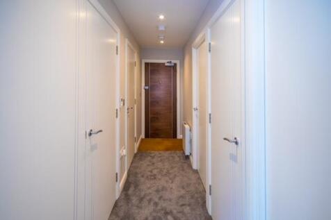 Bright, well-maintained hallway with soft carpe...