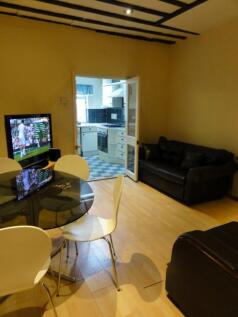 A cozy living room featuring a television, a ro...