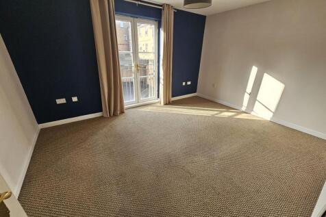 Bright, carpeted double bedroom with a large wi...