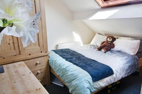 Bright, cozy attic bedroom with a comfortable d...