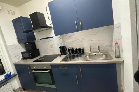 Modern compact kitchen with blue cabinetry, int...