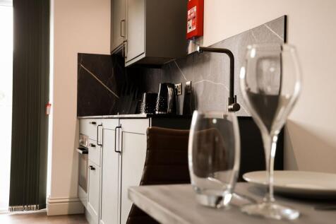 Modern fitted kitchen with marble backsplash...