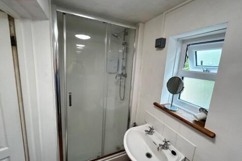 Bright bathroom with walk-in shower and window...