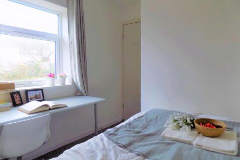 A cozy, well-lit bedroom featuring a comfortabl...