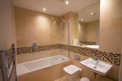 Modern tiled bathroom with a bathtub and integr...