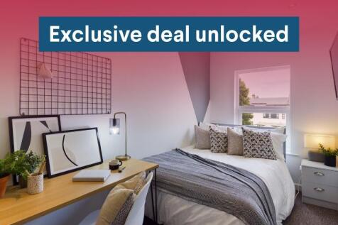 Bright, neatly styled double bedroom with a com...