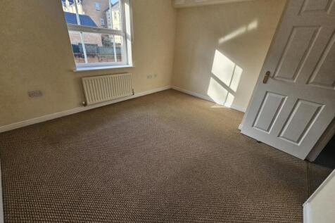 Bright, neutrally decorated bedroom with a larg...
