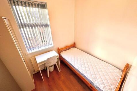 Bright room with bed, desk and large window...