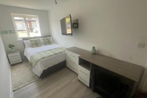 Bright bedroom with large desk and wall-mounted...