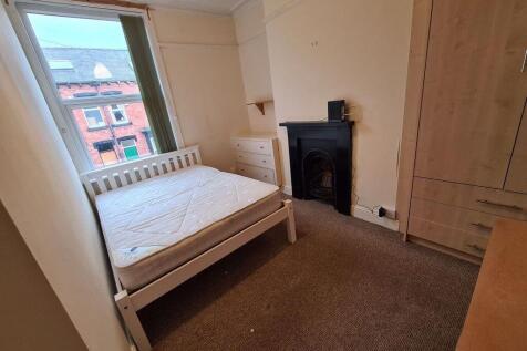 A cozy single bedroom with a white bed frame an...