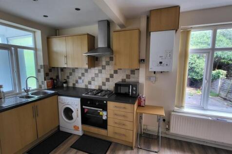 Bright fitted kitchen with light wood cabinetry...