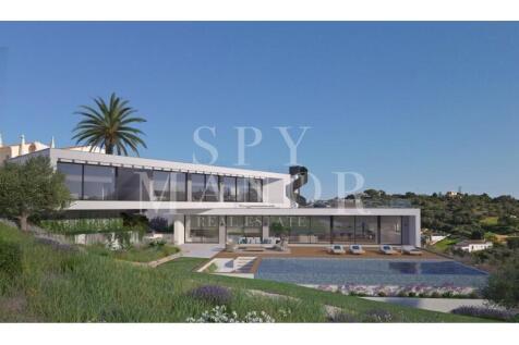 Modern architectural luxury villa exterior in Carvoeiro Algarve with large glass windows sun terrace and private swimming pool