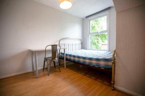 Bright simple bedroom with bed and desk...