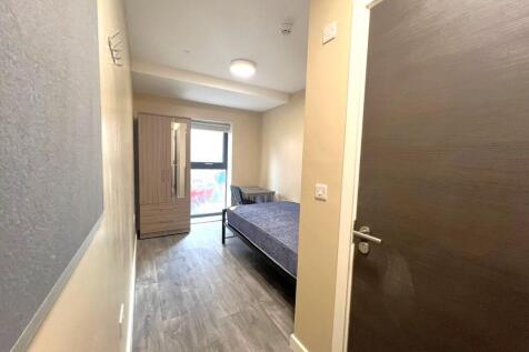 A clean, well-lit bedroom featuring a single be...