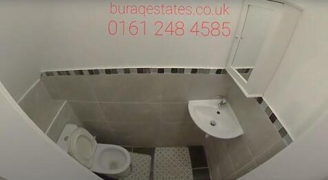 Compact, modern bathroom with tiled walls, a wa...