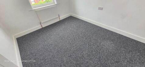 Bright bedroom with fresh carpet and natural li...