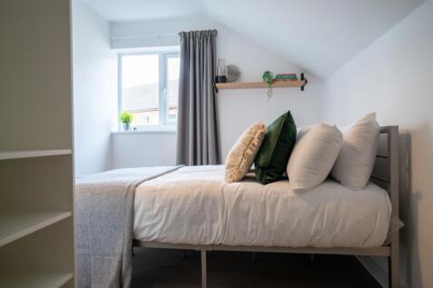 A bright and inviting double bedroom with styli...