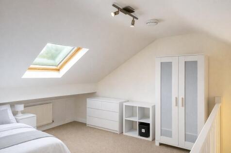 Bright loft bedroom with modern white storage...