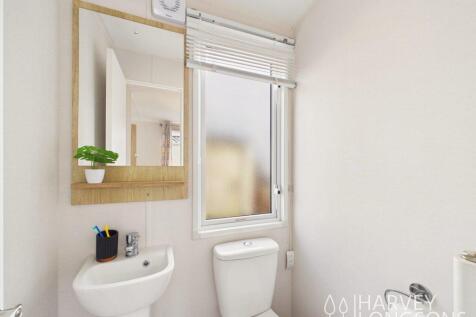 En-suite toilet with wash basin and mirror.