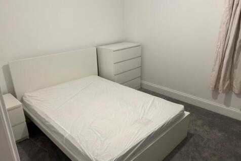 A spacious and tidy double bedroom with modern ...