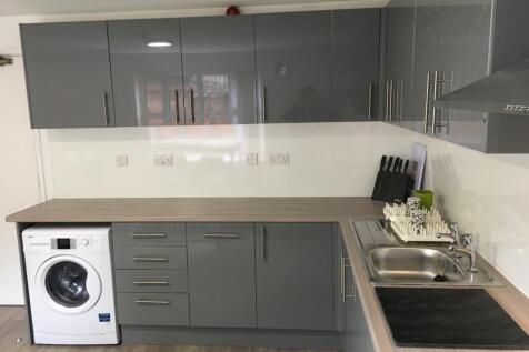 A modern and sleek kitchen featuring ample stor...