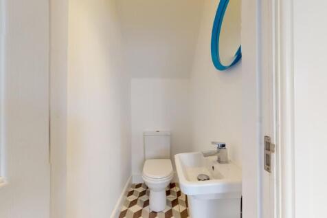 A clean and tidy single toilet with modern fixt...
