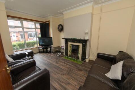 Spacious and well-lit living room with large wi...