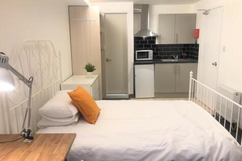 A cozy single bedroom featuring a neat white me...