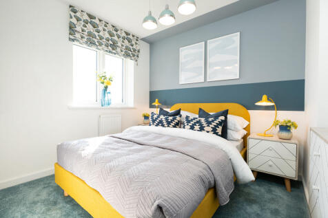 A cozy and vibrant bedroom with a yellow bed frame, patterned curtains