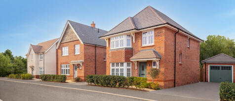 Modern red brick and cream-rendered detached houses with tiled roofs and well-maintained front garde