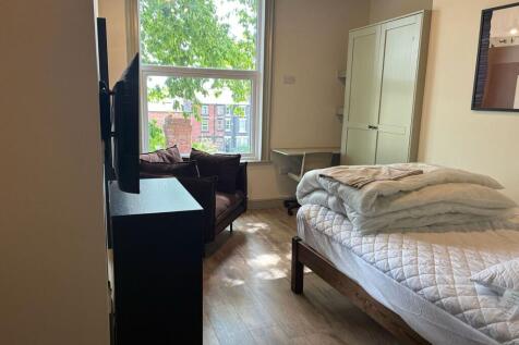 Bright bedroom with large window and study desk...