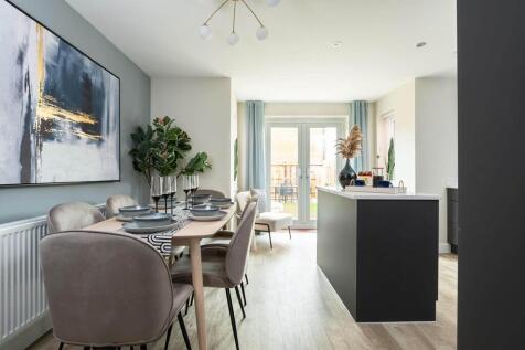 The open plan kitchen and dining area features double doors to the garden