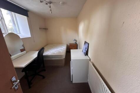 Neat single bedroom with a large window providi...