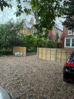 Spacious gravel driveway with leafy surrounding...