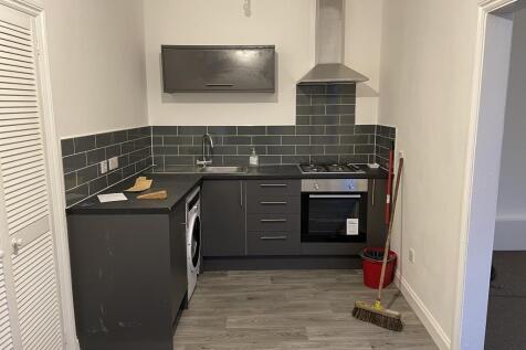 Contemporary kitchenette with dark cabinetry, b...