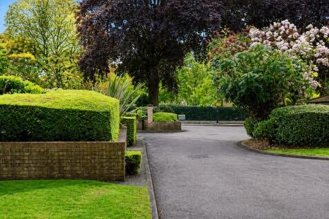 Lush, well-maintained garden with mature trees...