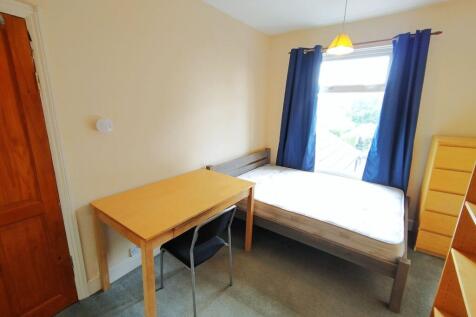 Bright single bedroom with a large window and n...