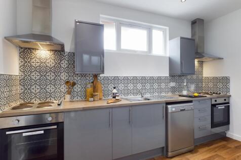 A modern and stylish kitchen featuring sleek gr...