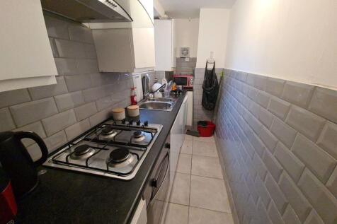 Bright, modern galley kitchen with tiled splash...