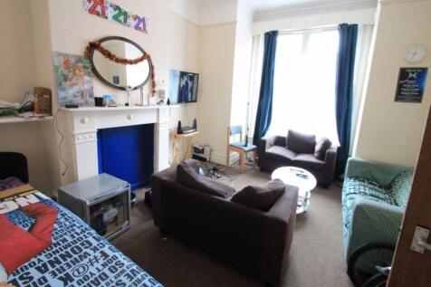 A cozy and well-lit single bedroom featuring a ...